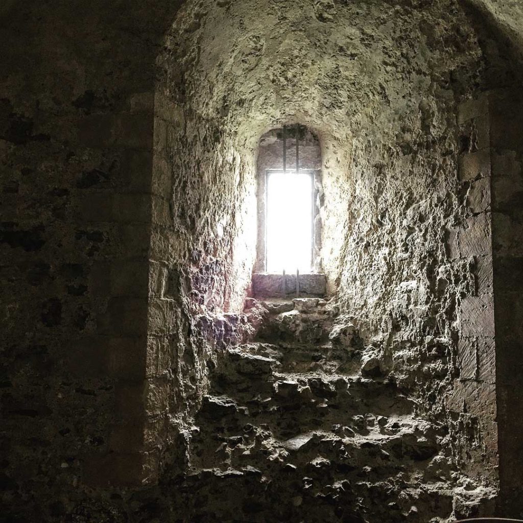 Light shining through a small stone window.