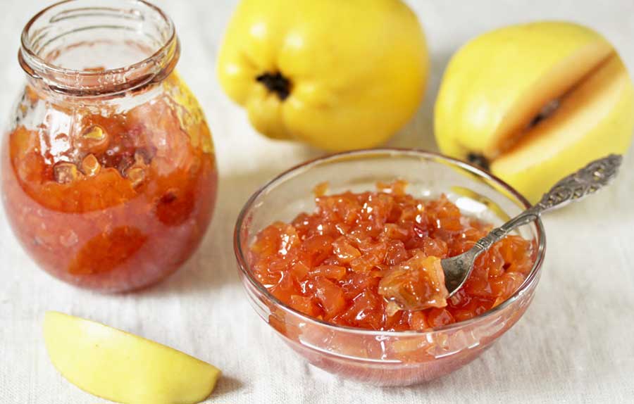 fresh quinces with quince jam in a bowl and jar