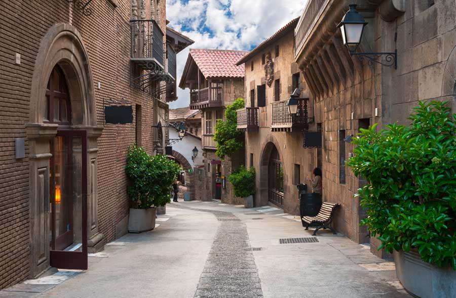 Traditional architecture and brick and stone houses along a narrow paved street