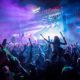 A crowd dancing to music at Sziget main stage with bright fluorescent lights