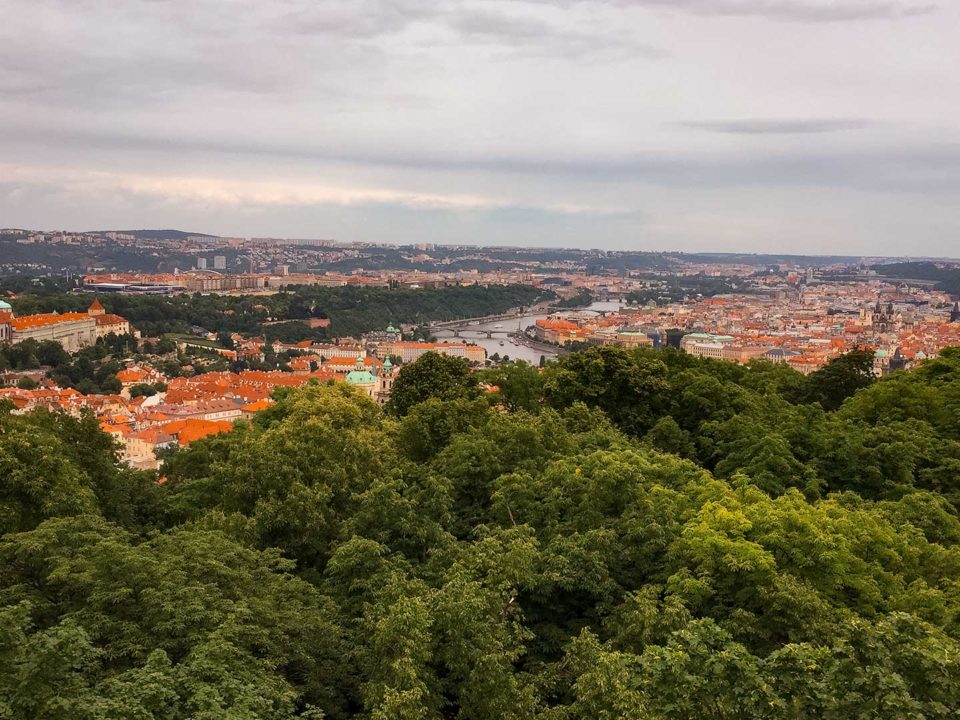 Panoramic view of the city of Prague with green forest and red roofs